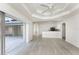 Open-concept living room with tray ceilings, sleek floors, and sliding doors to the lanai at 2168 Calcutta Rd, Punta Gorda, FL 33983