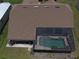 Back aerial view of a house featuring a screened-in pool and well-maintained landscaping at 23090 Ambassador Ave, Port Charlotte, FL 33954