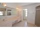 Bathroom featuring double sinks, large mirror, tiled floor and shower at 23090 Ambassador Ave, Port Charlotte, FL 33954