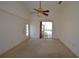 Large carpeted bedroom with ceiling fan and slider leading to outdoor patio at 23090 Ambassador Ave, Port Charlotte, FL 33954