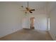 Large carpeted bedroom with ceiling fan and doorway to hallway at 23090 Ambassador Ave, Port Charlotte, FL 33954