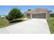 Inviting home featuring a lush lawn, landscaped front yard, and a spacious two-car garage at 23090 Ambassador Ave, Port Charlotte, FL 33954