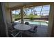 Enclosed pool featuring tile flooring, a large dining table, and clear views of the yard at 23090 Ambassador Ave, Port Charlotte, FL 33954