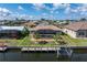 Aerial view of the waterfront property with dock, screened lanai, and well-maintained lawn at 2526 Rio Plato Dr, Punta Gorda, FL 33950