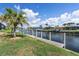 Canal-front backyard with a private dock, grassy area, and lush tropical landscaping for outdoor enjoyment at 2526 Rio Plato Dr, Punta Gorda, FL 33950