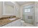 Bright bathroom boasts granite counters, a white vanity, and tiled shower with glass doors at 2526 Rio Plato Dr, Punta Gorda, FL 33950