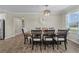 Dining room showcases wood-look tile floors, elegant light fixture, and large windows at 25308 Rupert Rd, Punta Gorda, FL 33983