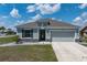 Charming single-story home with gray stucco, well-manicured lawn, stone accents, and a two-car garage at 25308 Rupert Rd, Punta Gorda, FL 33983