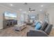Bright living room featuring wood-look tile flooring, a large sectional sofa, and a modern entertainment center at 25308 Rupert Rd, Punta Gorda, FL 33983