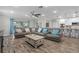 Open-concept living room with wood-look tile flooring, a sectional sofa, and views into the kitchen at 25308 Rupert Rd, Punta Gorda, FL 33983