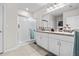 Bright bathroom with double sink vanity, tile flooring, walk-in shower with glass door and linen storage at 25312 E Lenox Cir, Punta Gorda, FL 33950