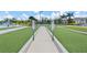 Bocce ball court with green turf, a bench, manicured landscaping, and clear skies at 25312 E Lenox Cir, Punta Gorda, FL 33950