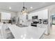 Well-lit kitchen with white cabinets, stainless appliances, and a large island with sink and breakfast bar at 25312 E Lenox Cir, Punta Gorda, FL 33950