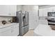 Modern kitchen featuring stainless steel appliances, white cabinetry and countertop, and tiled floors at 25312 E Lenox Cir, Punta Gorda, FL 33950