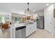 Open kitchen features stainless steel appliances, an island with a sink, and modern lighting at 25312 E Lenox Cir, Punta Gorda, FL 33950