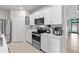 The kitchen features stainless appliances, white cabinets, tiled floors and modern lighting at 25312 E Lenox Cir, Punta Gorda, FL 33950