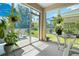 Enclosed lanai providing a peaceful retreat with potted plants and views of the lush backyard at 25312 E Lenox Cir, Punta Gorda, FL 33950