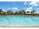 Inviting community pool with clear water, surrounding lounge chairs, palm trees, and blue skies at 25312 E Lenox Cir, Punta Gorda, FL 33950