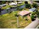 Waterfront home with boat dock on canal, surrounded by lush greenery and neighboring homes at 27193 And 27197 Voyageur Dr, Punta Gorda, FL 33983