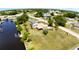 Aerial view of property with a large grass yard, palm trees, and waterfront access with private dock at 27193 And 27197 Voyageur Dr, Punta Gorda, FL 33983