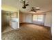 Living area has carpet flooring, ceiling fans, and an adjoining kitchen with neutral cabinets at 27193 And 27197 Voyageur Dr, Punta Gorda, FL 33983