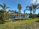 Picturesque waterfront with boat docks, palm trees, and access to open water at 27193 And 27197 Voyageur Dr, Punta Gorda, FL 33983