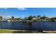 Scenic waterfront view featuring a boat lift and dock with serene water reflecting the blue sky at 27193 And 27197 Voyageur Dr, Punta Gorda, FL 33983