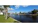 Picturesque waterfront view showcasing boat docks with lush landscaping and tranquil, glistening water at 27193 And 27197 Voyageur Dr, Punta Gorda, FL 33983