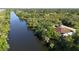 Aerial view of a home with a brown roof and long river surrounded by trees at 2955 Carmela Ave, North Port, FL 34286