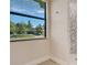 Bathroom window showcasing a serene view, complemented by stylish accent tiles at 2955 Carmela Ave, North Port, FL 34286