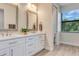 Bathroom featuring double sinks, framed mirrors, and a window at 2955 Carmela Ave, North Port, FL 34286