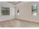 Bedroom featuring three large windows, light walls, and wood-look floors at 2955 Carmela Ave, North Port, FL 34286