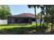 Exterior view of home featuring a large screened-in patio and grassy yard at 2955 Carmela Ave, North Port, FL 34286