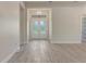 Bright and open foyer with front door, wood-look flooring, and recessed lighting at 2955 Carmela Ave, North Port, FL 34286