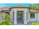 Inviting home featuring a blue front door, white columns, and manicured landscaping at 2955 Carmela Ave, North Port, FL 34286
