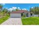Beautiful single-story home featuring a brick driveway, lush lawn, and attached two car garage at 2955 Carmela Ave, North Port, FL 34286