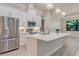 Bright kitchen featuring white cabinets, stainless steel appliances, and a large center island at 2955 Carmela Ave, North Port, FL 34286