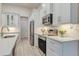 Bright kitchen featuring white cabinets, stainless steel appliances, and stylish backsplash at 2955 Carmela Ave, North Port, FL 34286