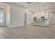 Open living space with wood-look flooring flows into the kitchen with white cabinetry at 2955 Carmela Ave, North Port, FL 34286