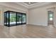 Spacious living room with neutral walls, wood look floors and large sliding glass doors at 2955 Carmela Ave, North Port, FL 34286
