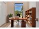 Bright office with a modern desk, wooden shelving, and a large window at 2955 Carmela Ave, North Port, FL 34286