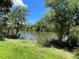 A scenic water view featuring lush grass, blue skies and palm trees at 2955 Carmela Ave, North Port, FL 34286