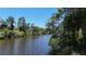 Scenic water view of a long river flowing through greenery and blue skies at 2955 Carmela Ave, North Port, FL 34286