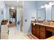 Well-lit bathroom showcasing tile flooring, a wooden vanity, and convenient access to a closet at 329 W Grace St, Punta Gorda, FL 33950