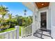 Charming covered front porch with white railings overlooks the landscaped yard and a light blue house at 329 W Grace St, Punta Gorda, FL 33950