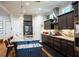 Modern kitchen featuring dark cabinetry, granite countertops, stainless appliances, and an island with bar stools at 329 W Grace St, Punta Gorda, FL 33950