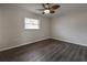 Inviting bedroom with hardwood floors, ceiling fan, and large window, offering a comfortable retreat at 406 Merlin Ct, Brandon, FL 33510