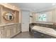 Elegant bathroom with dual vanities, standalone tub, and decorative tiles at 414 Caicos Dr, Punta Gorda, FL 33950