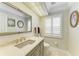 Elegant powder room featuring a marble vanity, designer fixtures, and subtle lighting, creating a sophisticated and serene space at 414 Caicos Dr, Punta Gorda, FL 33950
