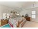 A cozy bedroom features a bed with floral linens, natural light, and ceiling fan at 414 Caicos Dr, Punta Gorda, FL 33950